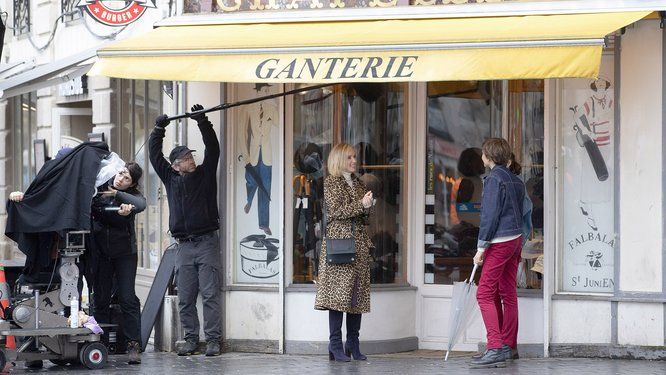 tournage avec techniciens et acteurs devant une devanture de magasin