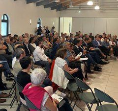 Christelle Morançais est debout avec un micro devant une salle comble de vendéens